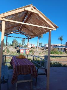 una mesa de picnic bajo un dosel de madera con una mesa gmaxwell gmaxwell gmaxwellzos en Sankayuni family homestay, en Ocosuyo