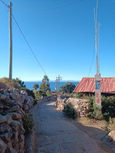 una pared de piedra junto a una carretera al lado de un edificio en Sankayuni family homestay, en Ocosuyo