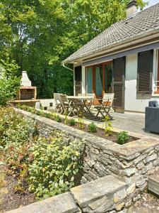 a patio with a table and chairs on a house at La maison du bois, 10 minutes de l'A71, 10 minutes de Bourges in Plaimpied-Givaudins