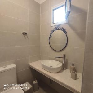 a bathroom with a sink and a mirror at Nafsika in Ammouliani +21 photos