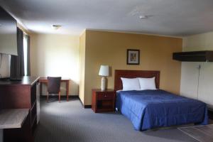 a hotel room with a bed and a desk at Esterhazy Motor Hotel in Esterhazy