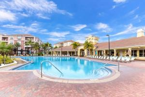 a swimming pool at a resort with chairs and palm trees at Vista Cay Condo, next to convention center, See World, Disney 3 in Orlando