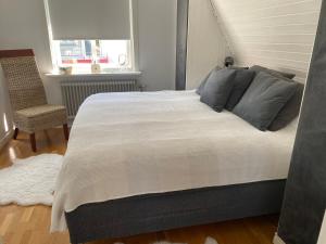 a bedroom with a large bed and a chair at Villa Rydholm 15 minutes from Gothenburg Center in Gothenburg