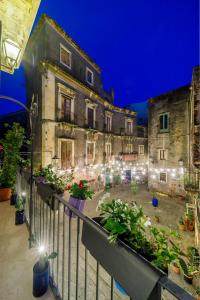 an old building with a courtyard with plants and lights at CASA NINNI in Catania +7 photos