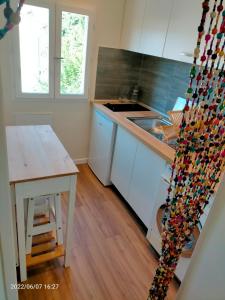 a kitchen with white cabinets and a wooden table at Superbe studio à Juan les pins in Juan-les-Pins