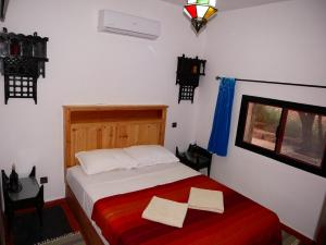 - une chambre avec un lit et 2 serviettes dans l'établissement petite jolie maison vue sur lac, à Bin el-Ouidane
