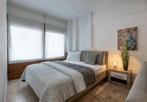 een slaapkamer met een groot bed en twee ramen bij Betty's DP Studio in Litóchoron