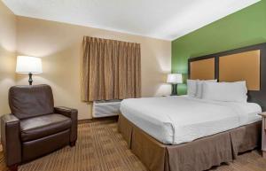 a hotel room with a bed and a chair at Extended Stay America Suites - Cincinnati - Blue Ash - Reagan Hwy in Blue Ash