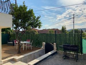a backyard with a fence and a table and a tree at Superbe studio à Juan les pins in Juan-les-Pins