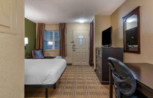 Habitación de hotel con cama, escritorio y TV. en Extended Stay America Suites - Lexington - Nicholasville Road en Lexington