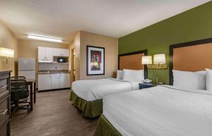 a hotel room with two beds and a kitchen at Extended Stay America Suites - Lexington - Nicholasville Road in Lexington