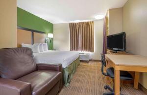 a hotel room with a bed and a desk and a chair at Extended Stay America Suites - Cincinnati - Blue Ash - Kenwood Road in Blue Ash