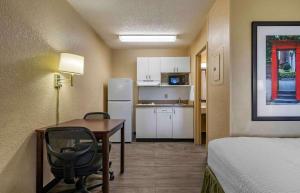 Habitación pequeña con escritorio y cocina. en Extended Stay America Suites - Lexington - Nicholasville Road en Lexington