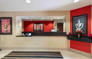 a lobby with a red wall and a cash counter at Extended Stay America Suites - Indianapolis - Airport in Indianapolis