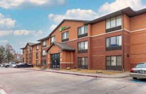 un bâtiment en briques avec des voitures garées dans un parking dans l'établissement Extended Stay America Suites - Fort Worth - Southwest, à Fort Worth