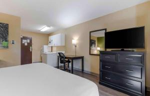 a hotel room with a bed and a flat screen tv at Extended Stay America Suites - Fort Worth - Southwest in Fort Worth