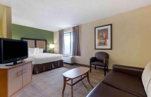 a hotel room with a bed and a flat screen tv at Extended Stay America Suites - Fort Worth - Southwest in Fort Worth