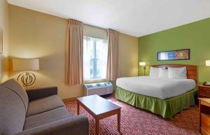 アトランタにあるExtended Stay America Suites - Atlanta - Northlakeのベッドとソファ付きのホテルルーム