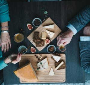 Dos personas sentadas en una mesa con comida y bebida en Biologen Herdla, en Herlø