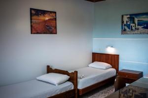 two beds in a room with blue walls at Katerina Studios & Apartments in Sidari