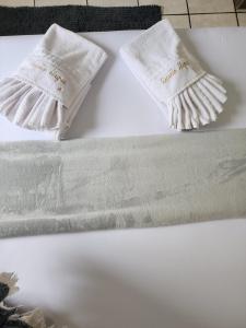 two white towels sitting on top of a table at Casa Recanto Alegria in Urubici