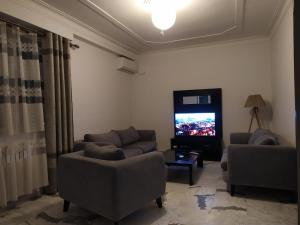 a living room with two couches and a flat screen tv at Appartement à louer à Tlemcen in Tlemcen