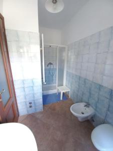 een badkamer met een douche, een toilet en een wastafel bij Casa Gaia 