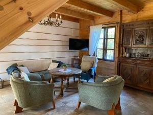 a living room with a couch and a table and chairs at Skansen Pomezania in Kałduny