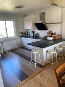 a kitchen with a black and white counter and stools at Villa Rydholm 15 minutes from Gothenburg Center in Gothenburg