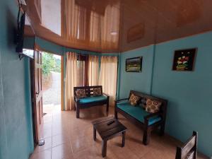 een woonkamer met 2 stoelen en een bank bij Jessie's Country House Rivas in Rivas