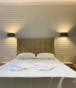 Una gran cama blanca con dos servilletas. en Gera Bay Studios And Apartments en Apidias Lakos