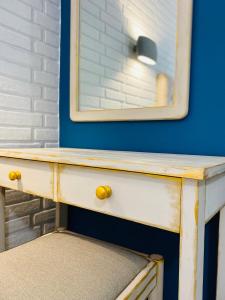 a wooden dresser with a mirror on a blue wall at Gera Bay Studios And Apartments in Apidias Lakos