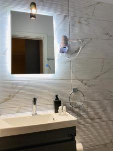a bathroom with a sink and a mirror at Gera Bay Studios And Apartments in Apidias Lakos