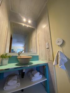 La salle de bains est pourvue d'un lavabo, d'un miroir et de serviettes. dans l'établissement Cabañas La Misión, à Salta