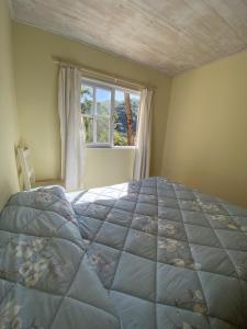 Un dormitorio con una cama grande y una ventana en Cabañas La Misión en Salta