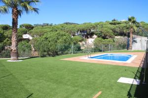 a large yard with a swimming pool and palm trees at Villa Galicia in Lloret de Mar