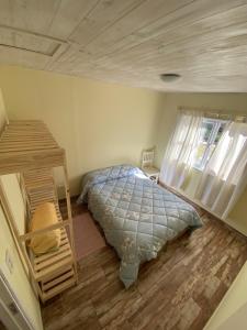 Schlafzimmer mit einem Bett und Holzboden in der Unterkunft Cabañas La Misión in Salta