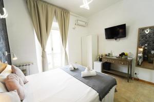 1 dormitorio con 1 cama blanca y TV en Cicero Rome Center, en Roma