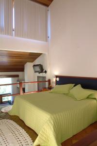 a bedroom with a large bed with a green blanket at Terracota Hotel in Itaipava
