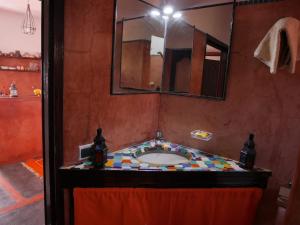 La salle de bains est pourvue d'un lavabo et d'un grand miroir. dans l'établissement petite jolie maison vue sur lac, à Bin el-Ouidane