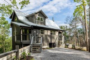 a small gray house with a metal roof at Cloudchaser Cabin, Private, New Cabin, 2 Kings, Cozy, Modern, Hot Tub, View, Theater in Sevierville