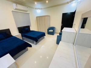 a bedroom with two beds and a chair in it at شقة واسعة بفناء خاص و دخول ذاتي in Al Madinah
