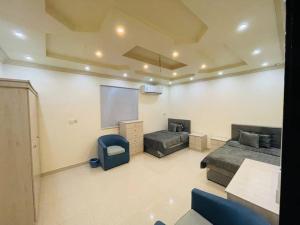 a living room with two beds and a chalkboard at شقة واسعة بفناء خاص و دخول ذاتي in Al Madinah