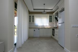 a kitchen with white cabinets and a sink at Paradise Town Villa Lisa in Belek