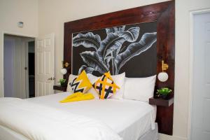 a bedroom with a white bed with a large headboard at King Bed Studio/Gated/Fast Wi-Fi/Near Ocho Rios in Boscobel