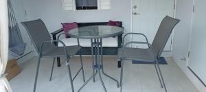 een glazen tafel en stoelen in een kamer bij King Bed Studio/Gated/Fast Wi-Fi/Near Ocho Rios in Boscobel