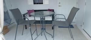 a glass table and chairs in a room at King Bed Studio/Gated/Fast Wi-Fi/Near Ocho Rios in Boscobel
