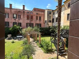 un patio con un edificio y una palmera en Zen Accommodation Grand Canal, en Venecia
