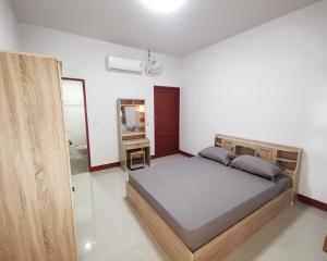 um quarto com uma cama grande e um espelho em ห้องเช่าพิภูตะวัน 