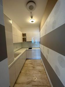 uma cozinha com armários brancos e piso em azulejo em Seaside Delight em Budva